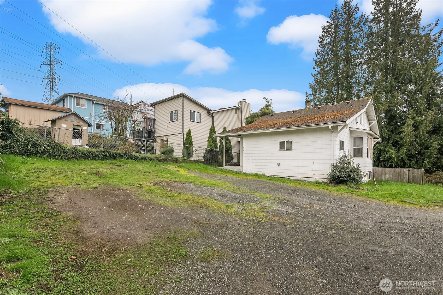 5154 South Creston Street Seattle, WA 98178 - Photo 2 of 8 a view of a white house next to a yard with big trees