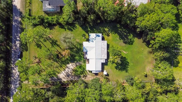 an aerial view of residential house with swimming pool and large trees