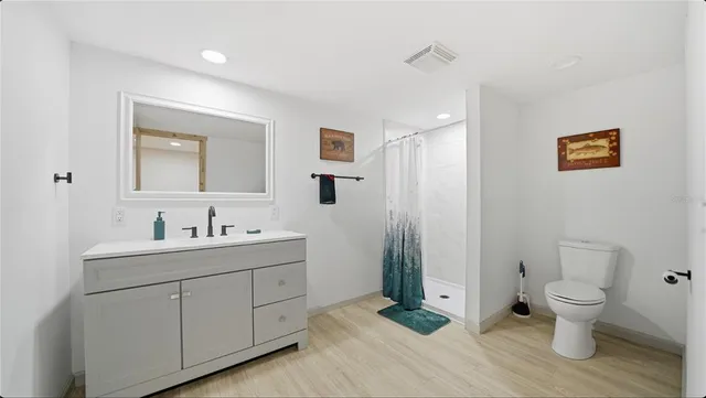 a spacious bathroom with a toilet sink and mirror