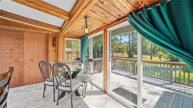 a view of a patio with table and chairs and wooden floor