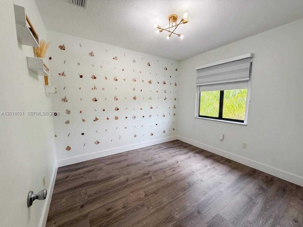 1575 Southeast 20th Road Homestead, FL 33035 - Photo 11 of 19 a view of an empty room with a window and wooden floor
