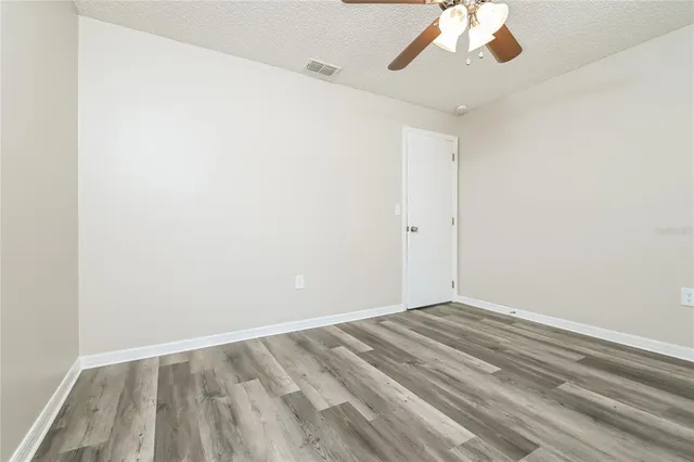 an empty room with a window and a fan
