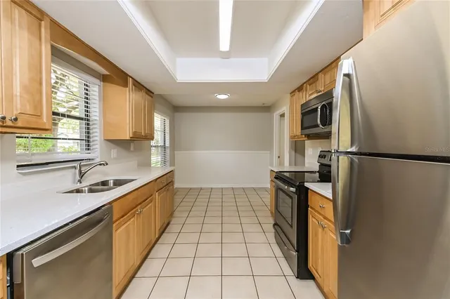 a large kitchen with stainless steel appliances granite countertop a stove a sink and a refrigerator