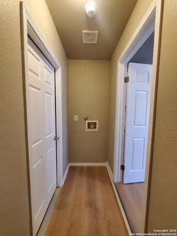 a view of a hallway with wooden floor