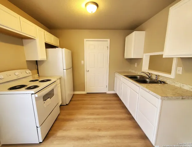 a kitchen with a stove a sink and a refrigerator