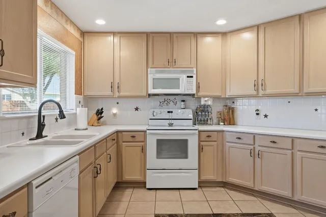 a kitchen with white cabinets appliances and a sink