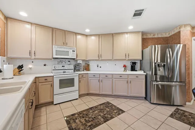 a kitchen with a refrigerator sink and cabinets