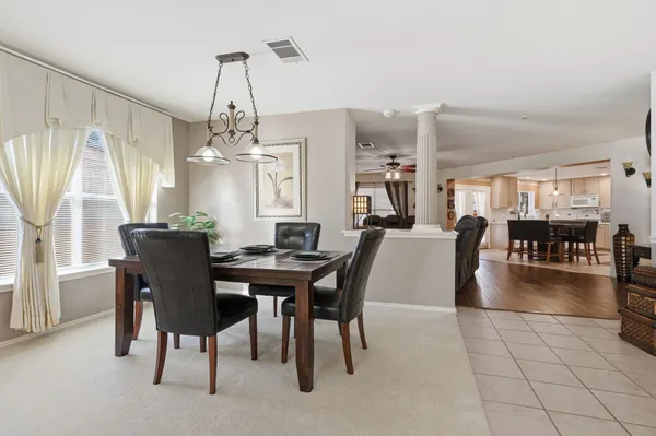 a view of a dining room and livingroom with furniture wooden floor a chandelier