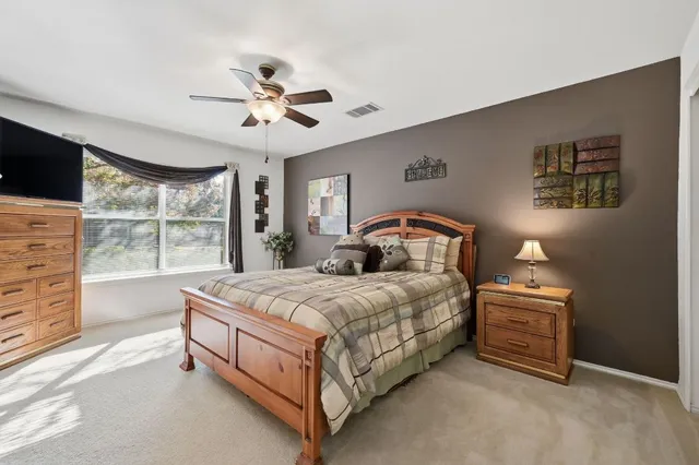 a bedroom with a bed a chandelier and a window