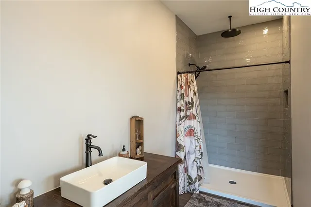 a bathroom with a sink a mirror and shower