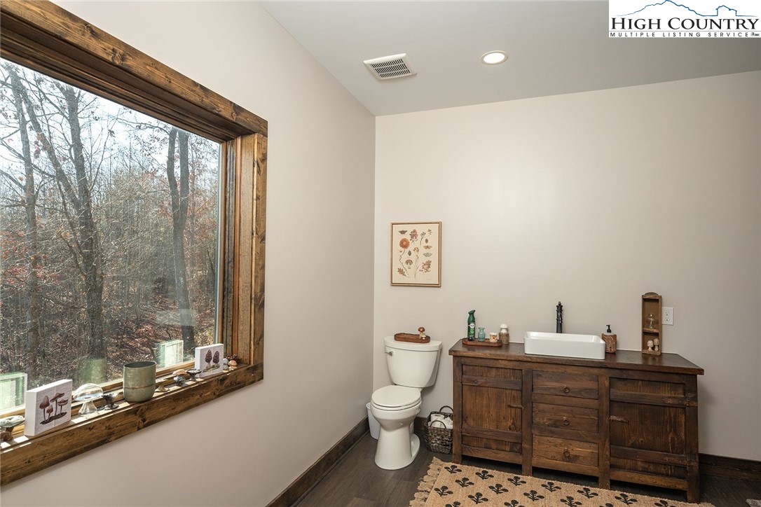 414 Elk Horn Road Ferguson, NC 28624 - Photo 14 of 27 a bathroom with a toilet a sink and a mirror