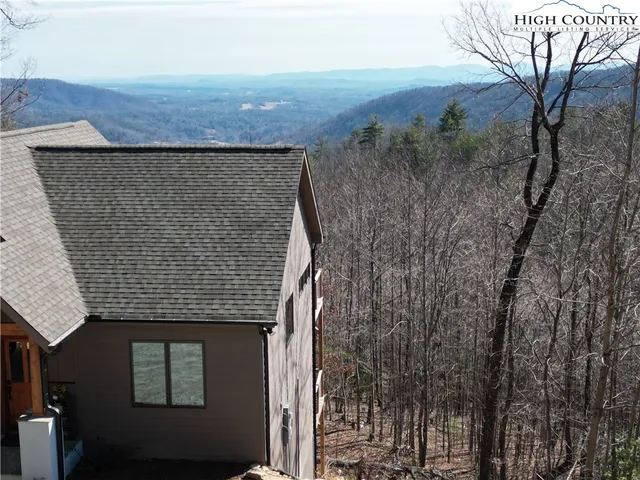 a aerial view of a house with a yard and large tree