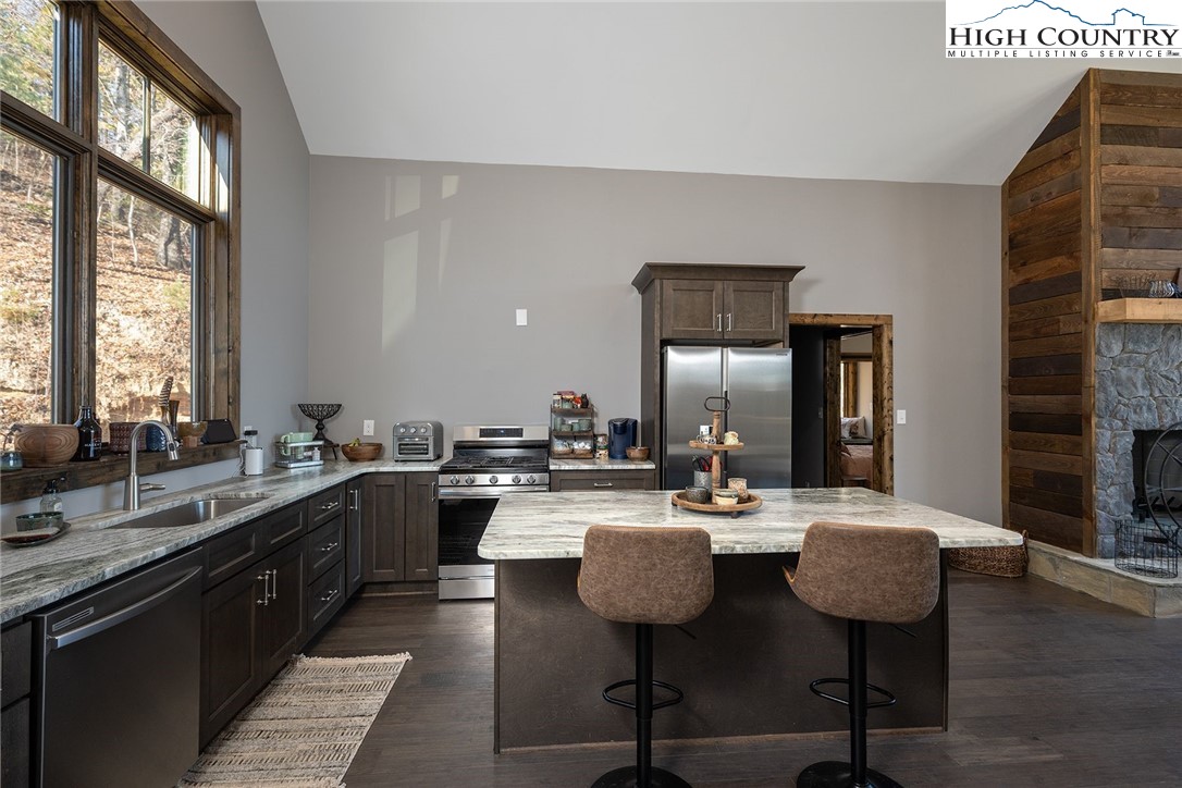 414 Elk Horn Road Ferguson, NC 28624 - Photo 4 of 27 a kitchen with a sink a stove and chairs with wooden floor