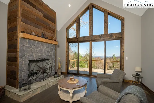 a living room with furniture a fireplace and a floor to ceiling window