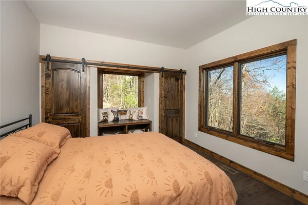 a bedroom with a bed and a large window