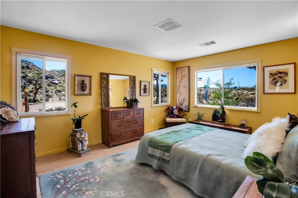 59489 Onaga Trail Joshua Tree, CA 92252 - Photo 20 of 73 a bedroom with a bed and large windows