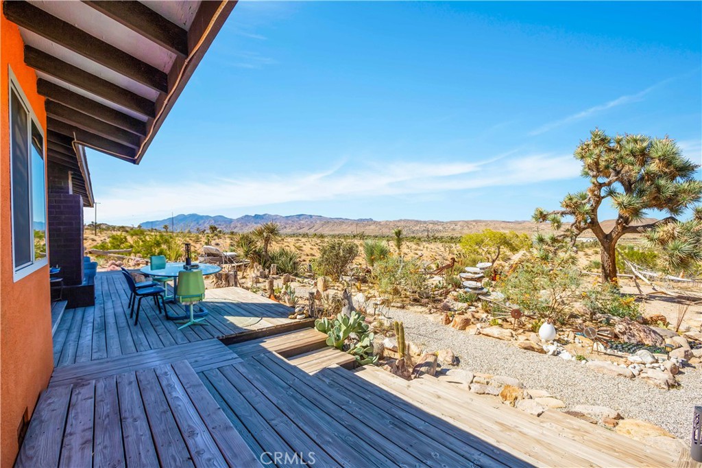 59489 Onaga Trail Joshua Tree, CA 92252 - Photo 29 of 73 a view of a balcony with chair and wooden floor