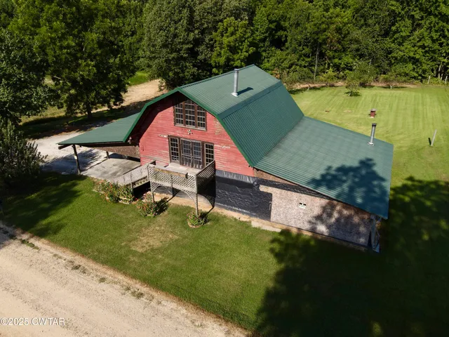 an aerial view of a house with a yard basket ball court and outdoor seating
