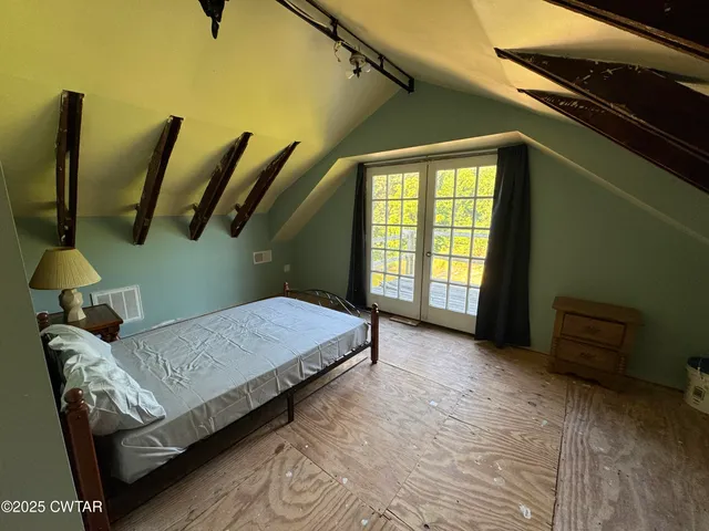a bedroom with a bed and a wooden floor
