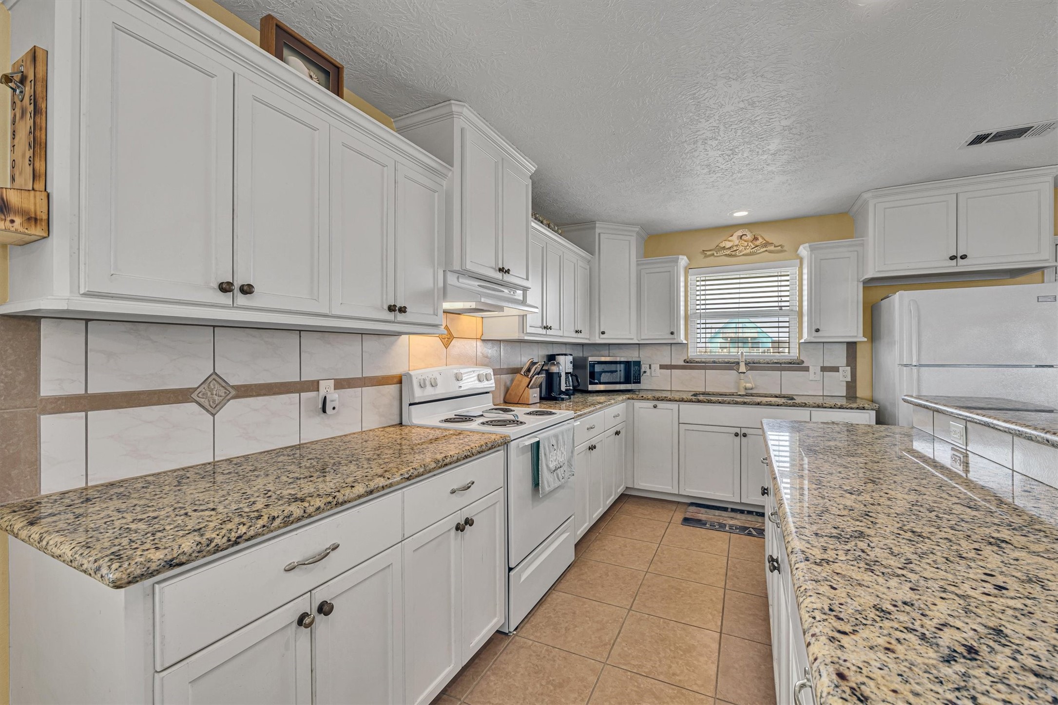 818 Seashell Drive Freeport, TX 77541 - Photo 10 of 23 a kitchen with granite countertop a sink stainless steel appliances and cabinets