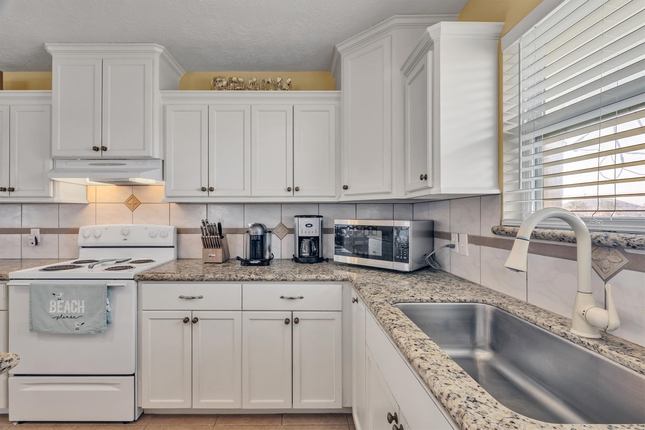 818 Seashell Drive Freeport, TX 77541 - Photo 12 of 23 a kitchen with granite countertop a sink a stove and cabinets