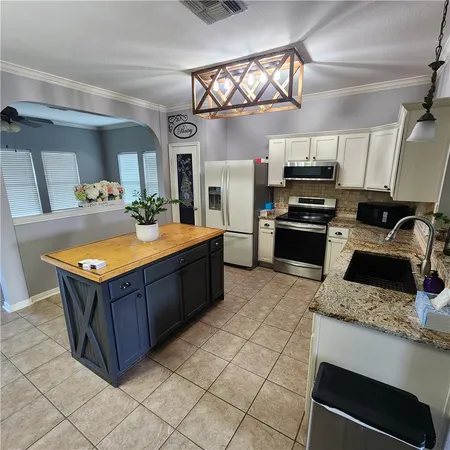 a kitchen with stainless steel appliances granite countertop a stove a sink and a refrigerator