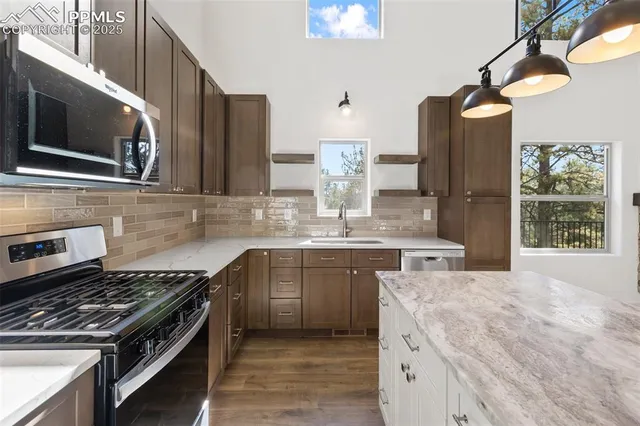 a kitchen with stainless steel appliances granite countertop a stove and a sink