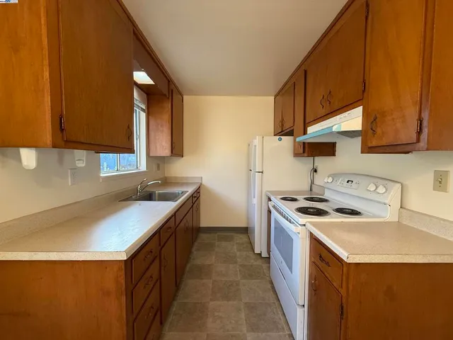 a kitchen with a sink stove top oven and cabinets