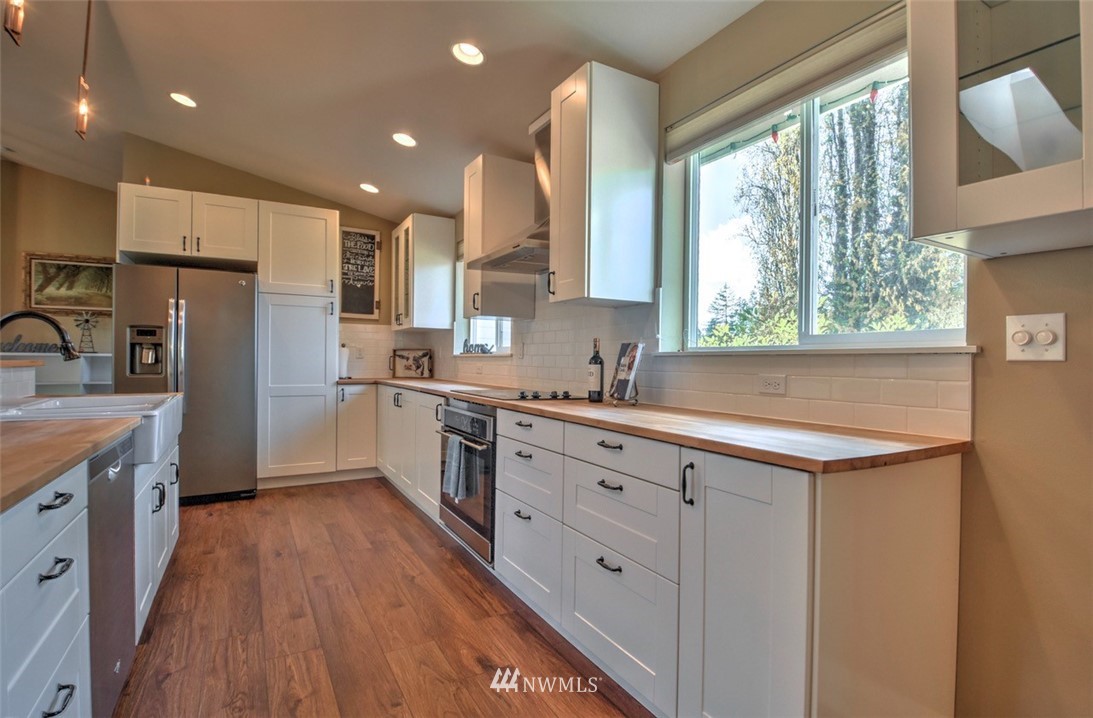 6131 Maytown Road Southwest Olympia, WA 98512 - Photo 11 of 39 a kitchen with granite countertop a sink appliances cabinets and counter space