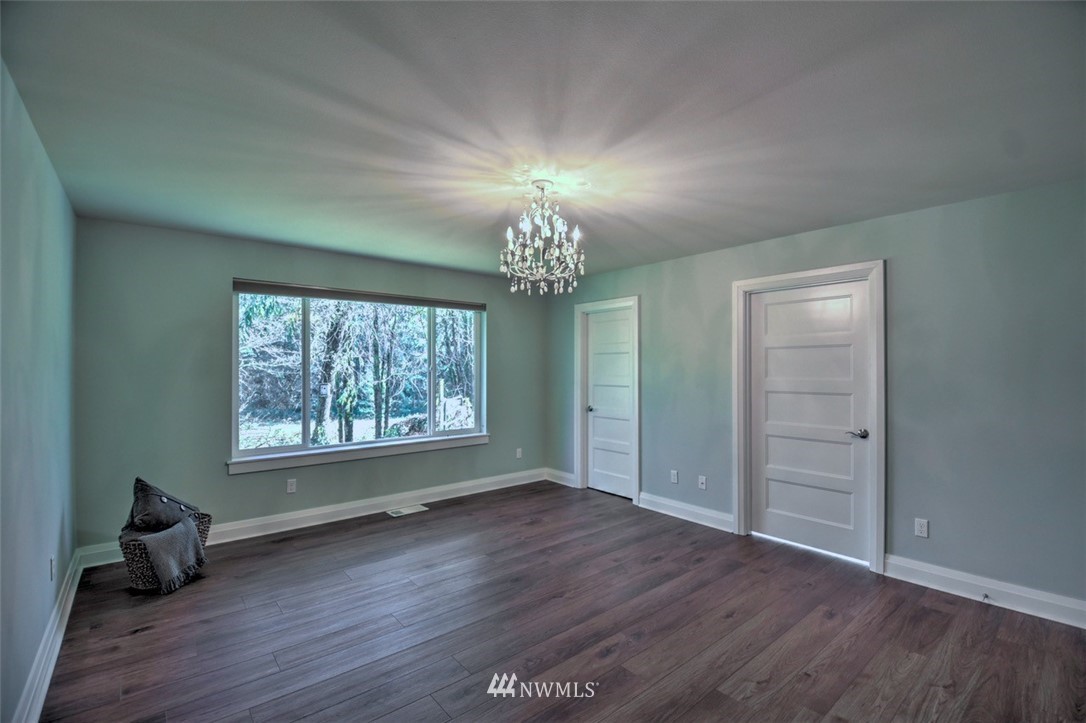 6131 Maytown Road Southwest Olympia, WA 98512 - Photo 19 of 39 an empty room with wooden floor chandelier and windows