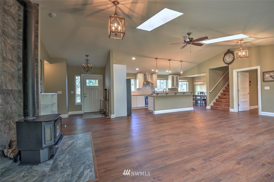 6131 Maytown Road Southwest Olympia, WA 98512 - Photo 3 of 39 a view of a living room a kitchen and a chandelier fan