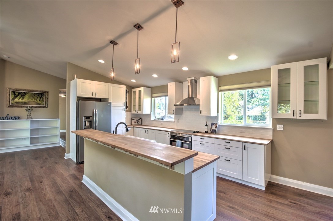 6131 Maytown Road Southwest Olympia, WA 98512 - Photo 9 of 39 a large kitchen with kitchen island a stove a sink a center island and wooden floor