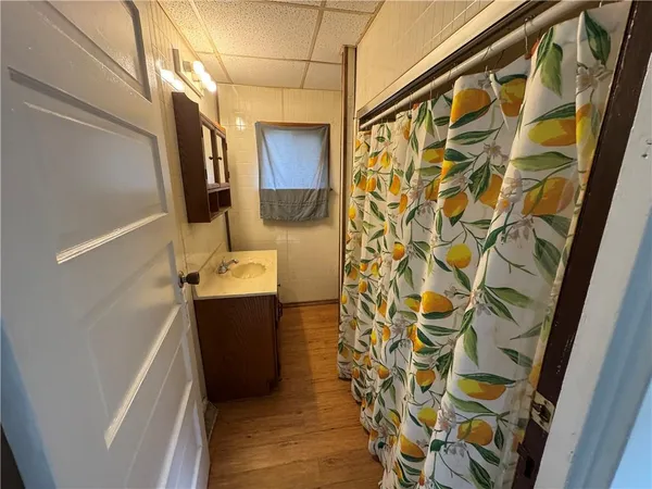 a bathroom with a sink and mirror with bathtub