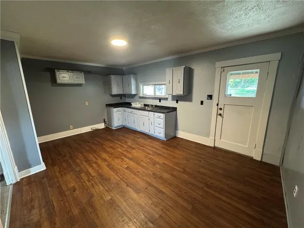 a kitchen with granite countertop a stove and wooden floor