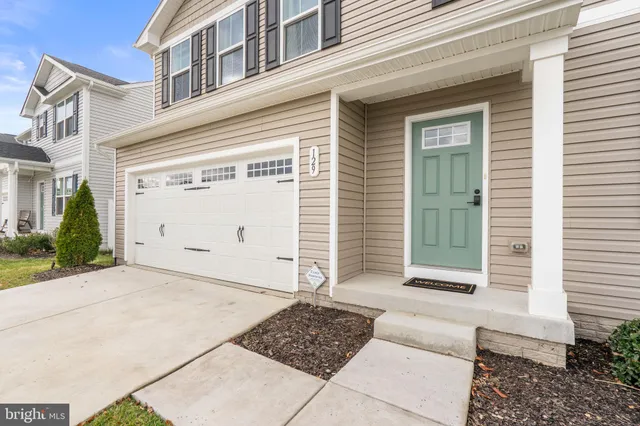 a large white room with kitchen island a sink wooden floor and a refrigerator