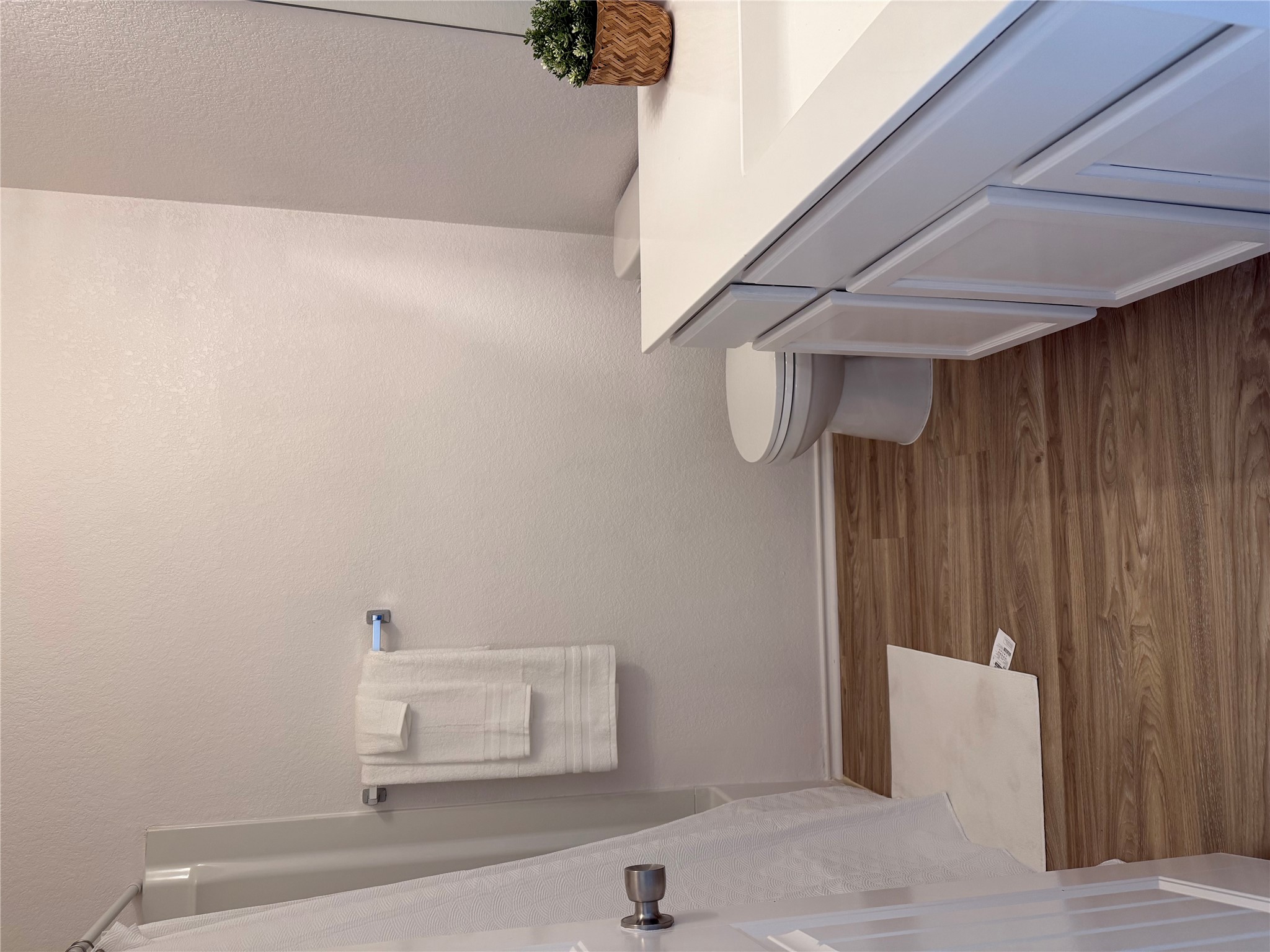 14907 Retha Pass Austin, TX 78725 - Photo 17 of 22 A pristine bathroom features wood flooring and a modern white vanity with clean lines.