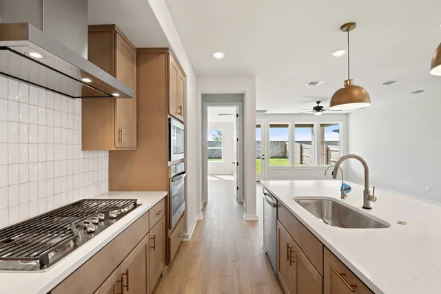 a kitchen with stainless steel appliances granite countertop a sink stove and refrigerator