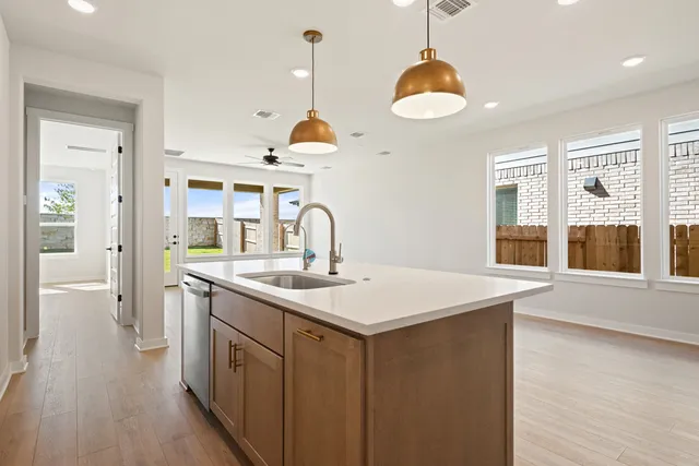 a kitchen with stainless steel appliances granite countertop a sink a stove and a wooden floors