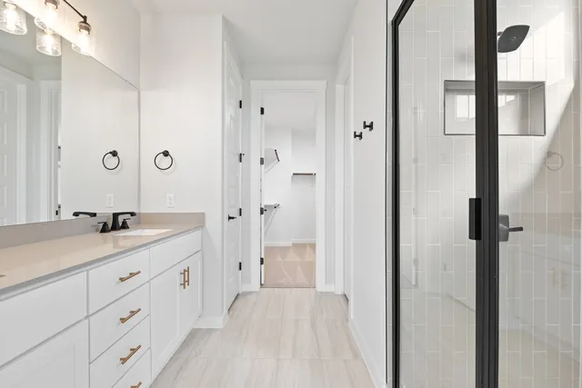 a spacious bathroom with a granite countertop sink a mirror and a shower