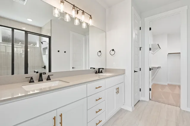 a bathroom with double vanity sinks and a mirror