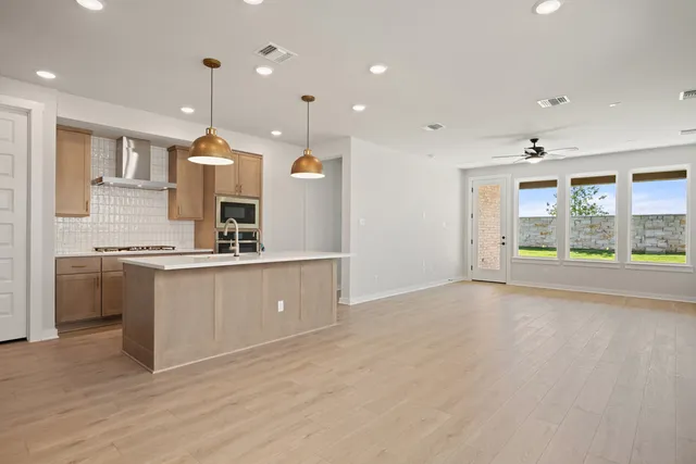 a large kitchen with a large window a sink stainless steel appliances and a counter top space