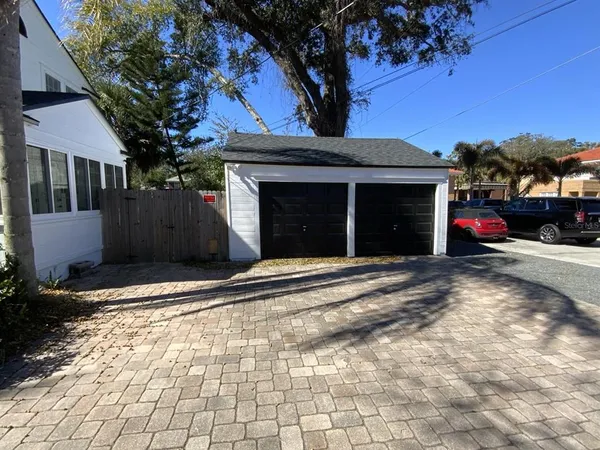 a view of a house with a yard and a large tree