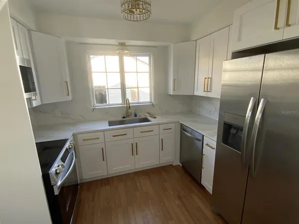 a kitchen with stainless steel appliances white cabinets and a sink