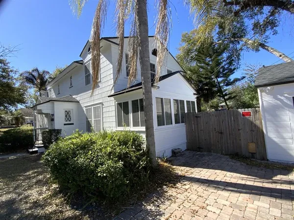 a view of a white house next to a yard