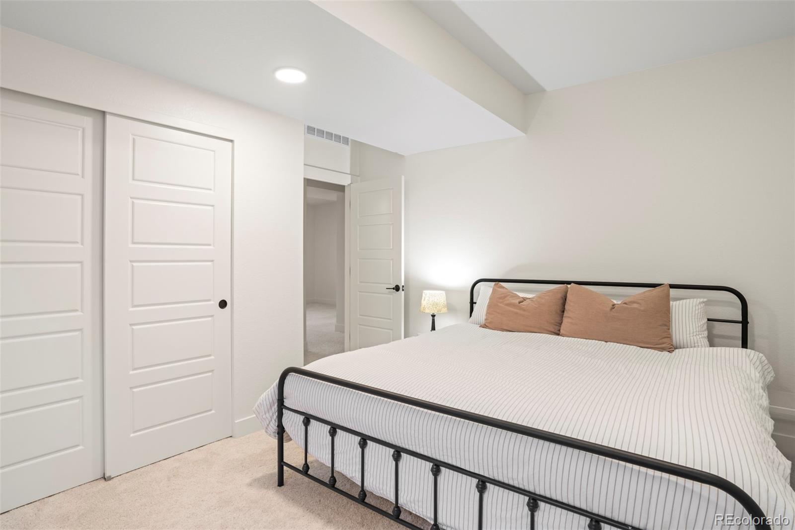 4899 Daven Road Morrison, CO 80465 - Photo 24 of 27 a bedroom with a large bed and a chandelier