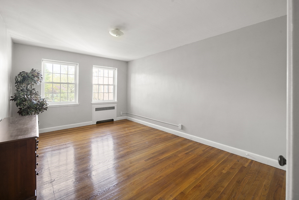 42 Browne Street, Unit 3 Brookline, MA 02446 - Photo 13 of 15 an empty room with wooden floor and windows