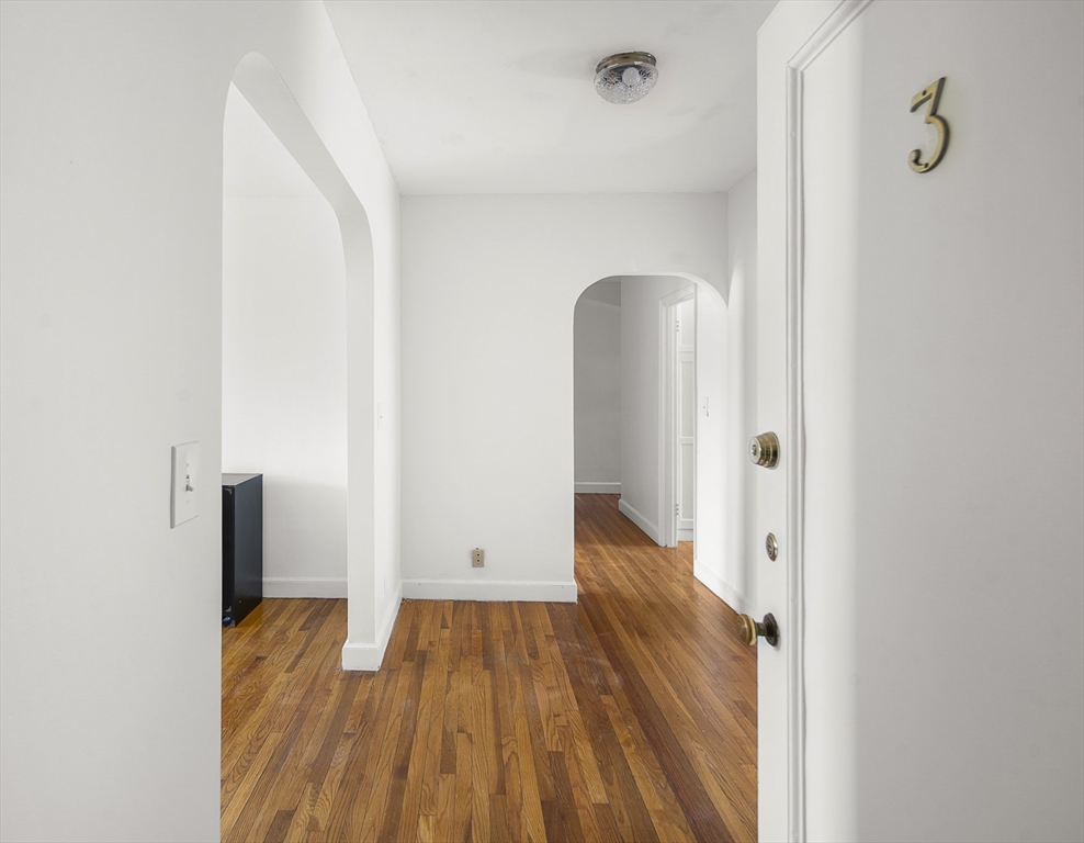 42 Browne Street, Unit 3 Brookline, MA 02446 - Photo 3 of 15 a view of hallway with wooden floor