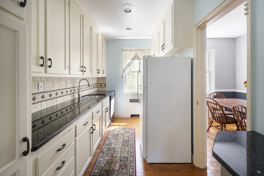42 Browne Street, Unit 3 Brookline, MA 02446 - Photo 9 of 15 a kitchen with stainless steel appliances granite countertop a refrigerator a sink and white cabinets