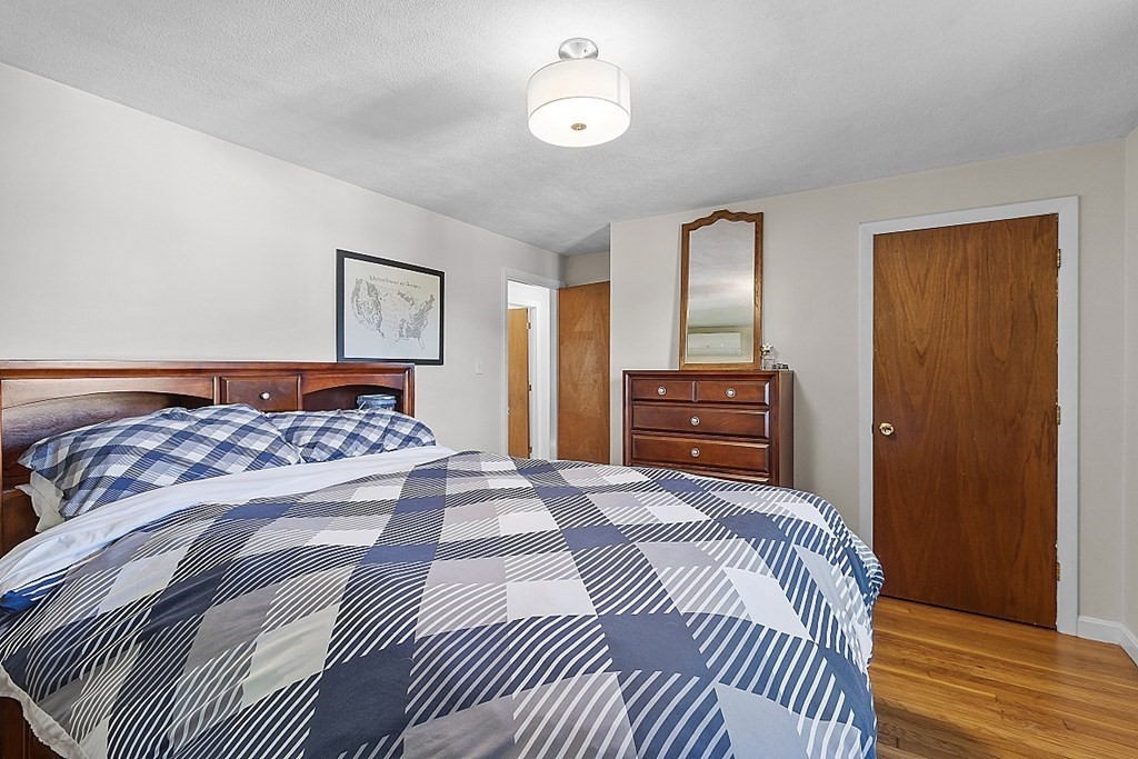 233 College Farm Road Waltham, MA 02451 - Photo 12 of 41 a bedroom with a large bed and a chandelier