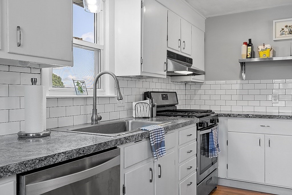 233 College Farm Road Waltham, MA 02451 - Photo 9 of 41 a kitchen with granite countertop a sink stainless steel appliances and white cabinets